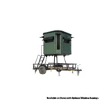 Redneck elevated hunting blind with dark green exterior on trailer for transportation.