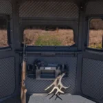 Interior of Redneck hunting blind with gun carrier, windows, carpet, sound treated walls, and storage space.