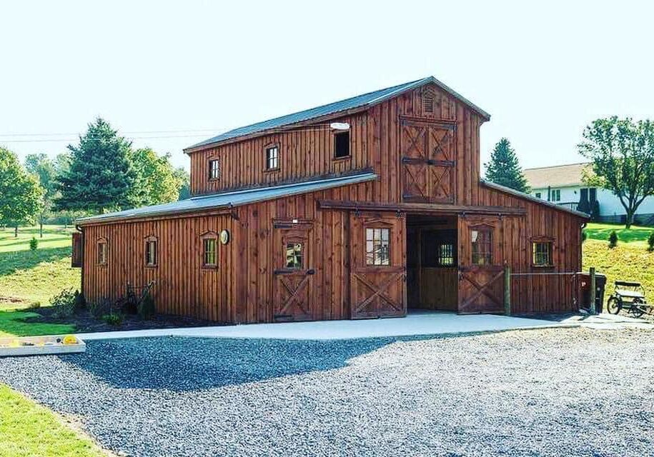 Large custom outdoor structure and storage barn, two stories with wood detail. Barn doors and accents around.