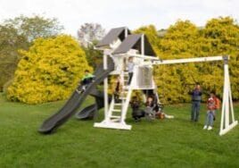 Children playing outside on a black and white vinyl commercial swing set in the yard.